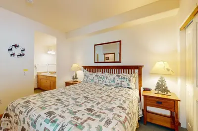 a bedroom with a bed and a sink and a mirror at Eagle Run 113 in Mammoth Lakes