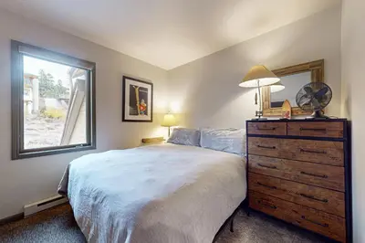 a bedroom with a bed with a dresser and a window at Eagle Run 206 in Mammoth Lakes