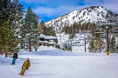 two people are standing in the snow on a ski slope at Mammoth Green 101 in Mammoth Lakes