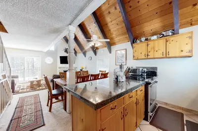 a kitchen with wooden cabinets and a dining room at Mammoth View Villas 30 in Mammoth Lakes