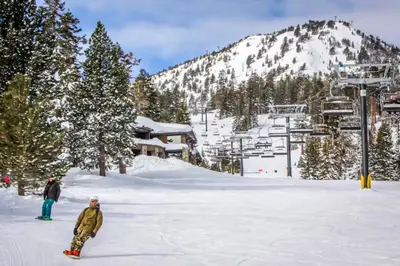 two people are standing in the snow on a ski slope at Mammoth View Villas 30 in Mammoth Lakes