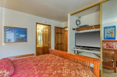 a bedroom with a bed and a flat screen tv at Snowflower 54 in Mammoth Lakes