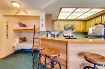 a kitchen with bar stools and a bunk bed at Sierra Megeve 9 in Mammoth Lakes