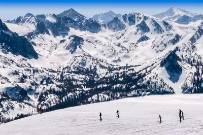 a group of people skiing down a snow covered mountain at Sierra Megeve 9 in Mammoth Lakes