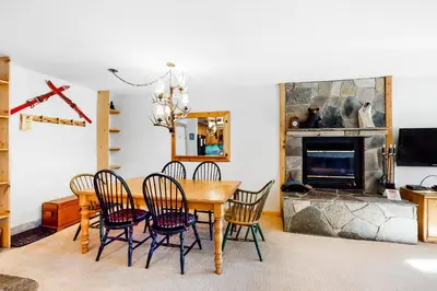 a dining room with a table and chairs and a fireplace at The Summit 67 in Old Mammoth