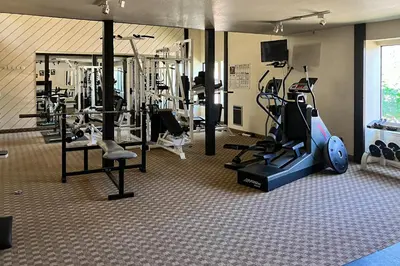 a gym with several treadmills and machines in a room at The Summit 67 in Old Mammoth