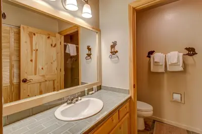 a bathroom with a sink and a toilet and a mirror at Snowcreek 233 in Mammoth Lakes