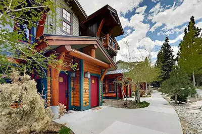 a wooden house with colorful doors on a street at Lodestar Cabins in Mammoth Lakes