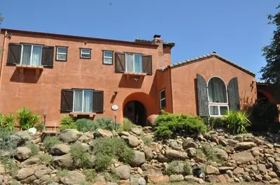 a brick house on a hill with rocks in front at Posada Mariana Bed and Breakfast in Catheys Valley