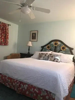 a bedroom with a large bed with a ceiling fan at Posada Mariana Bed and Breakfast in Catheys Valley