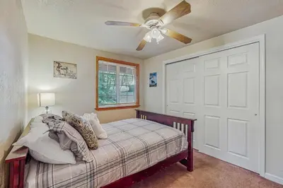 a bedroom with a bed and a ceiling fan at Charming Tahoe Chalet in Tahoe Valley
