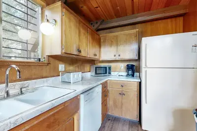 a kitchen with wooden cabinets and a white refrigerator at Donner Lakefront Retreat in Truckee