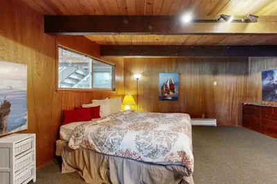 a bedroom with a bed in a room with wooden walls at Donner Lakefront Retreat in Truckee