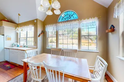 a dining room with a table and chairs and windows at Great Escape Cabin (08/253) in Groveland