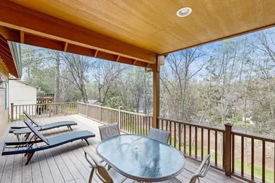 a patio with a glass table and chairs on a deck at Mule Deer Cabin (4-538) in Groveland
