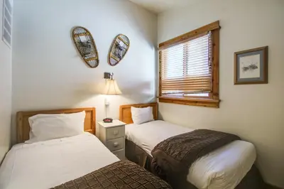 a bedroom with two beds and a window with a lamp at Northstar Ski Trails in Truckee