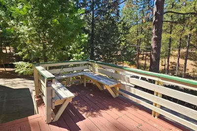 a wooden bench sitting on top of a wooden deck at Forest Treasure (01/497) in Groveland