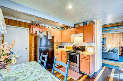 a kitchen with wooden cabinets and a black refrigerator at Foxglove Terrace in South Lake Tahoe