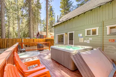 a backyard with a hot tub and chairs on a deck at Foxglove Terrace in South Lake Tahoe