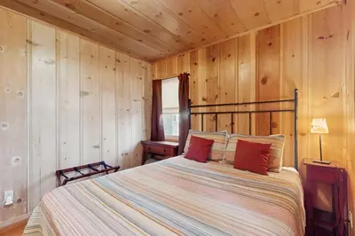 a bedroom with a bed in a wooden wall at Cozy Bobby Grey Manor in South Lake Tahoe