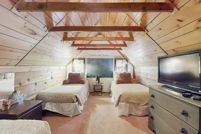 a room with two beds and a flat screen tv at Cozy Bobby Grey Manor in South Lake Tahoe