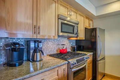 a kitchen with wooden cabinets and a stove top oven at Tahoe Keys Waterfront with Dock in South Lake Tahoe