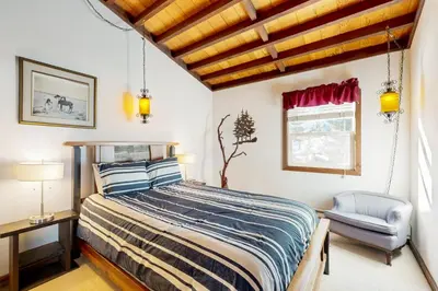 a bedroom with a bed and a chair and a window at Squaw Valley Views Condo #15 in Olympic Valley