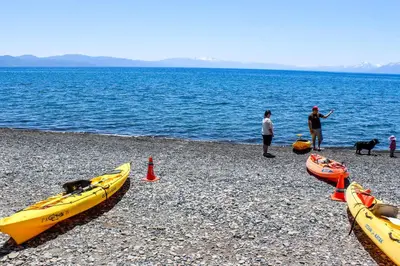 a group of people and three kayaks on a beach at Carnelian Woods Sanctuary in Carnelian Bay