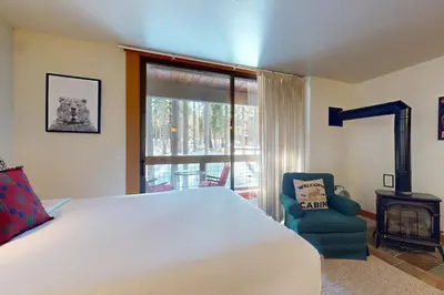a bedroom with a bed and a chair and a window at Aspen Grove Hideaway in Truckee