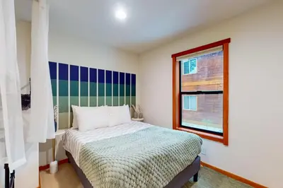 a small bedroom with a bed and a window at Sierra Solstice in Truckee