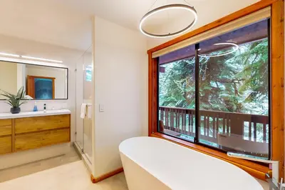 a bedroom with a large window and a sink and a mirror at Sierra Solstice in Truckee