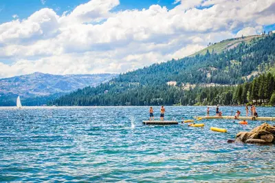 a group of people standing on a dock in a lake at Sierra Solstice in Truckee