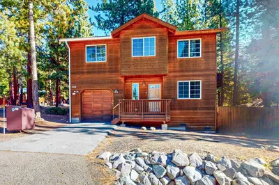 a wooden house with a garage and a driveway at Wanderlust Cabin in Kings Beach