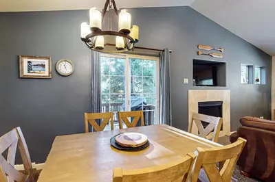 a dining room with a table and a clock on the wall at Wanderlust Cabin in Kings Beach