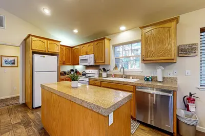 a kitchen with wooden cabinets and a white refrigerator at Wanderlust Cabin in Kings Beach