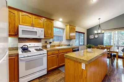 a kitchen with wooden cabinets and a white stove top oven at Wanderlust Cabin in Kings Beach