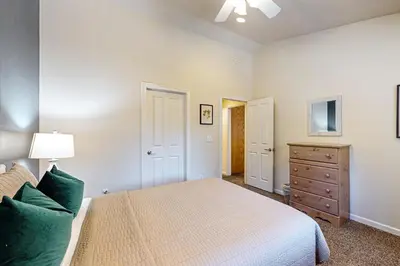 a bedroom with a bed and a dresser with a lamp at Wanderlust Cabin in Kings Beach