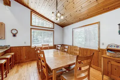 a dining room with a wooden table and chairs at Fawn Lodge in Tahoe Vista