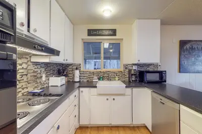 a white kitchen with a sink and a stove at West Shore Lakeview Beauty* in Homewood