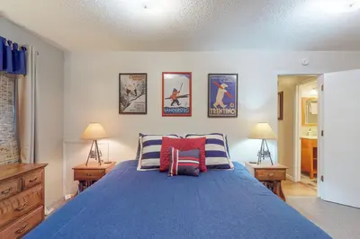 a bedroom with a blue bed with two lamps and pictures on the wall at West Shore Lakeview Beauty* in Homewood