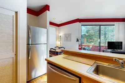 a kitchen with a refrigerator and a sink at Christy Lane Condo in Olympic Valley