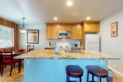 a kitchen with a counter with stools and a counter top at Nordic Retreat in Kings Beach
