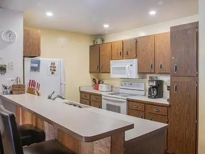 a kitchen with wooden cabinets and a white refrigerator at Streamside Townhome in Kings Beach