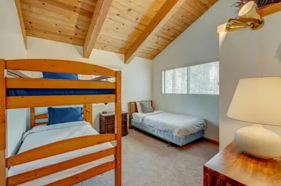 a bedroom with two bunk beds and a desk at Beaver Pond Northstar Luxury Chalet with Hot Tub in Truckee