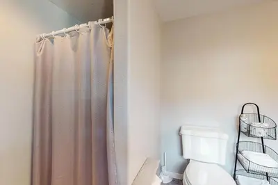 a bathroom with a shower curtain and a toilet at Solvang Family Getaway in Truckee