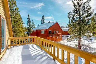 a balcony with a red barn in the snow at Solvang Family Getaway in Truckee