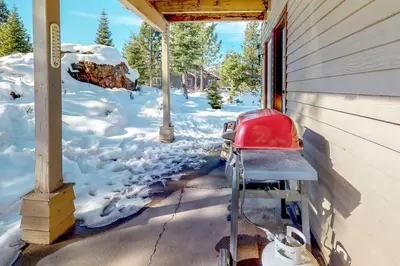 a red chair sitting on a porch in the snow at Solvang Family Getaway in Truckee