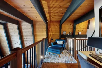 an attic room with a blue chair and a desk at Canterbury Kings Beach Treehouse in Kings Beach