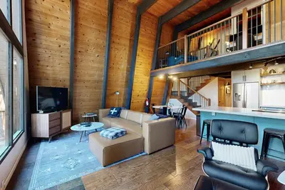 a living room with a couch and a tv at Canterbury Kings Beach Treehouse in Kings Beach