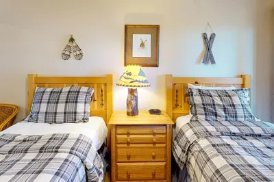 a bedroom with two beds and a lamp on a night stand at View Condo at Northstar in Truckee